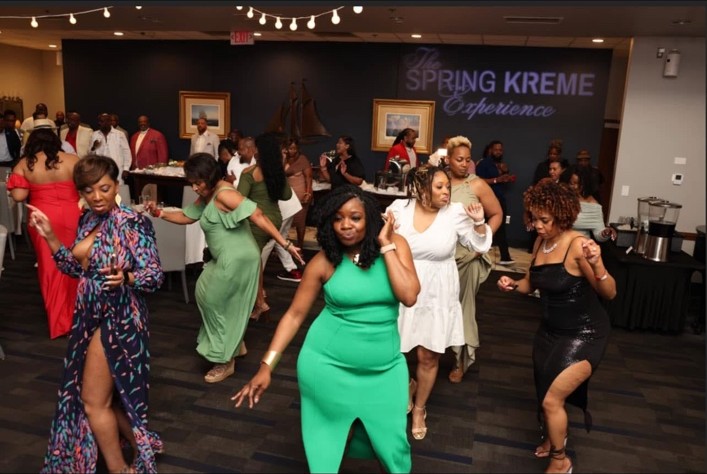 Guests dancing beneath the Spring Kreme Experience projection